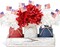 Patriotic table decor with mason jars, mini flags, and red, white, blue accents.
